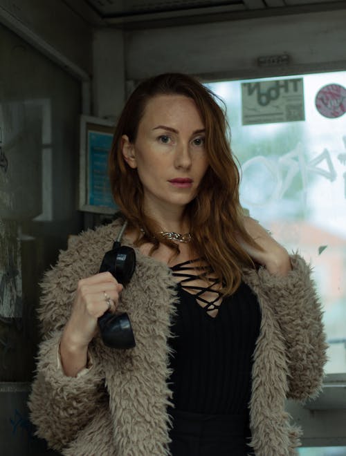 Beautiful Woman in Fur Coat Posing with Telephone in Hand