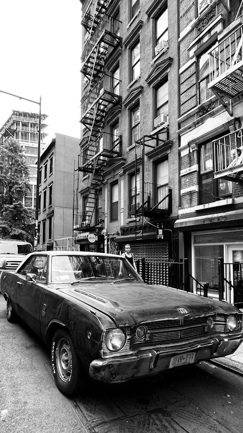 Vintage Car Parked on the Side of the Street in front of a Building in City 