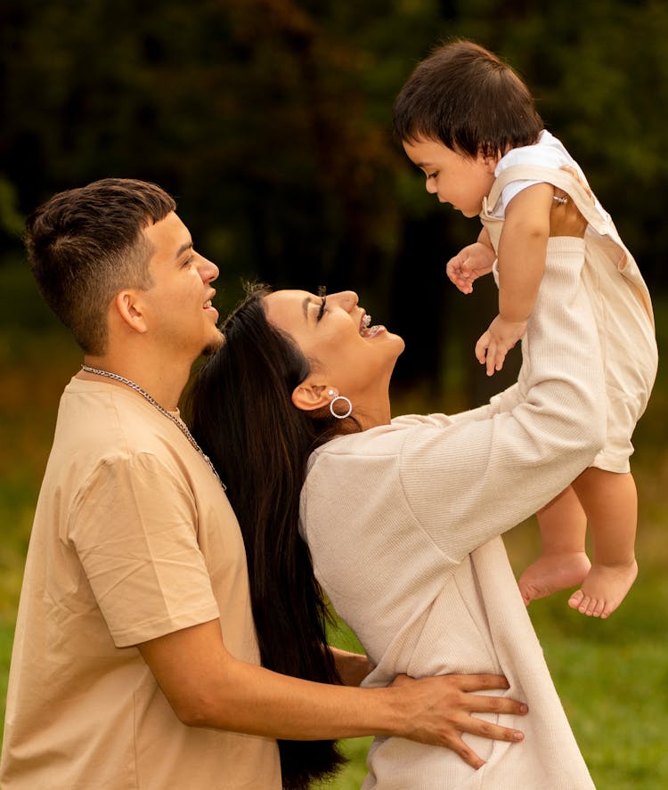 A Family Holding A Little Girl And Smiling