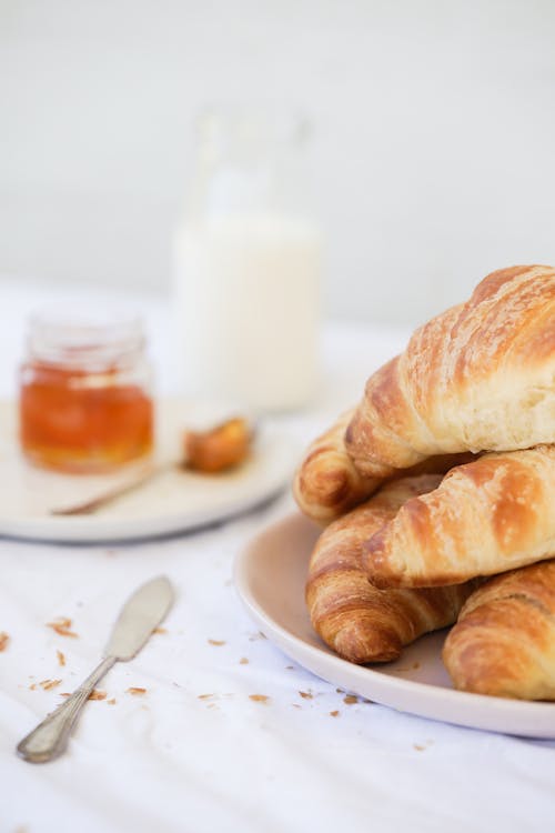 Close-up of a Plate with Croissants and a Jar with Jam 