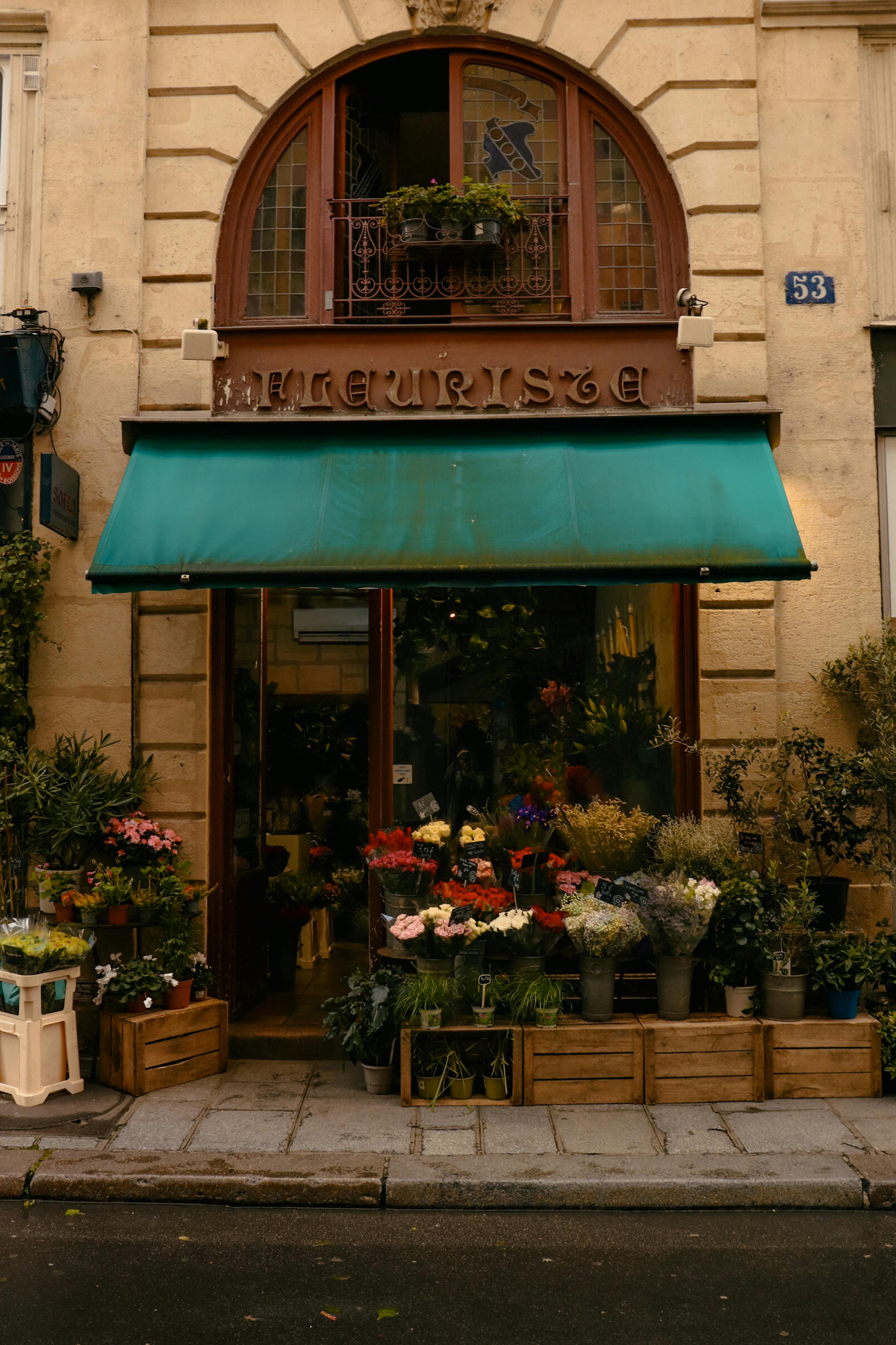 Charming Parisian flower shop with colorful blooms and vintage architecture on a sunny day.