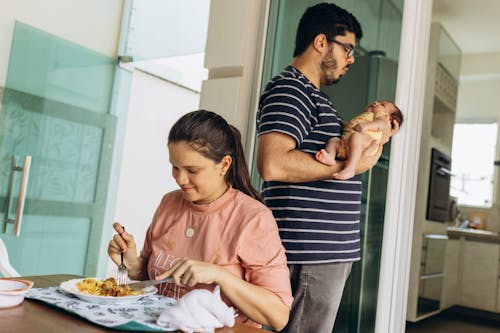 Mother Eating and Father Holding Baby behind