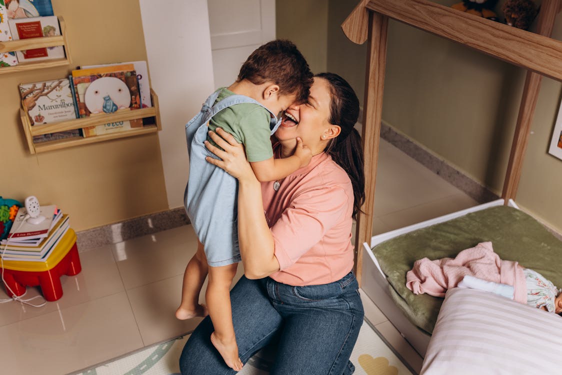 Free Mother Kneeling and Holding and Hugging Son Stock Photo