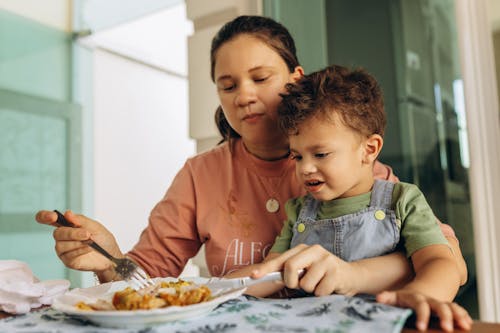 Free A woman and a child eating food together Stock Photo