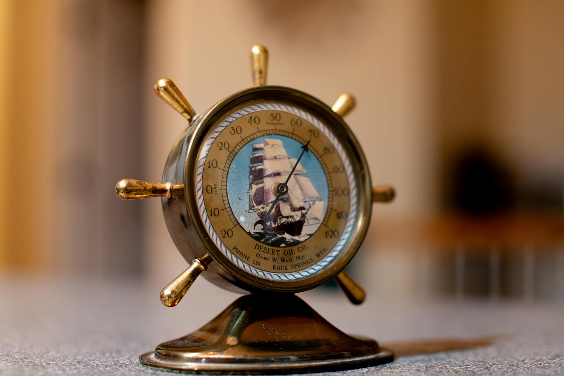 Elegant vintage brass barometer styled as a ship's helm, perfect for nautical decor enthusiasts.