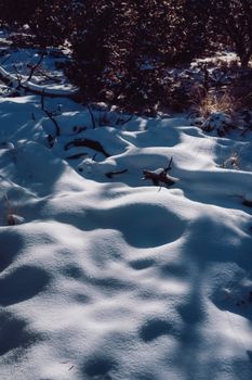 Tranquil snowy landscape in winter, showcasing untouched snow with shadows in a natural setting.
