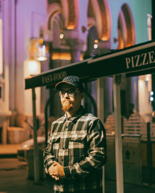 Man Standing in Check Shirt by Restaurant