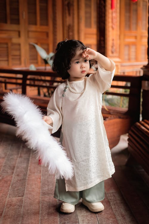 Little Girl in White Dress Standing on Terrace