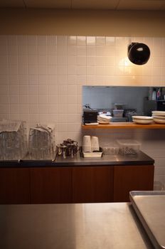 Contemporary kitchen interior featuring organized tableware and modern lighting under warm ambiance.