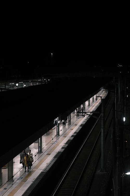 People Walking on a Train Station Platform at Night