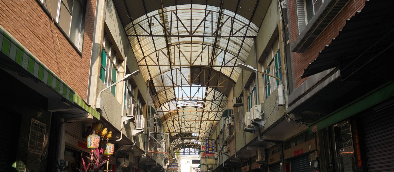 Discover a bustling urban alleyway with shops in Pingtung County, Taiwan, under an intricate roof.