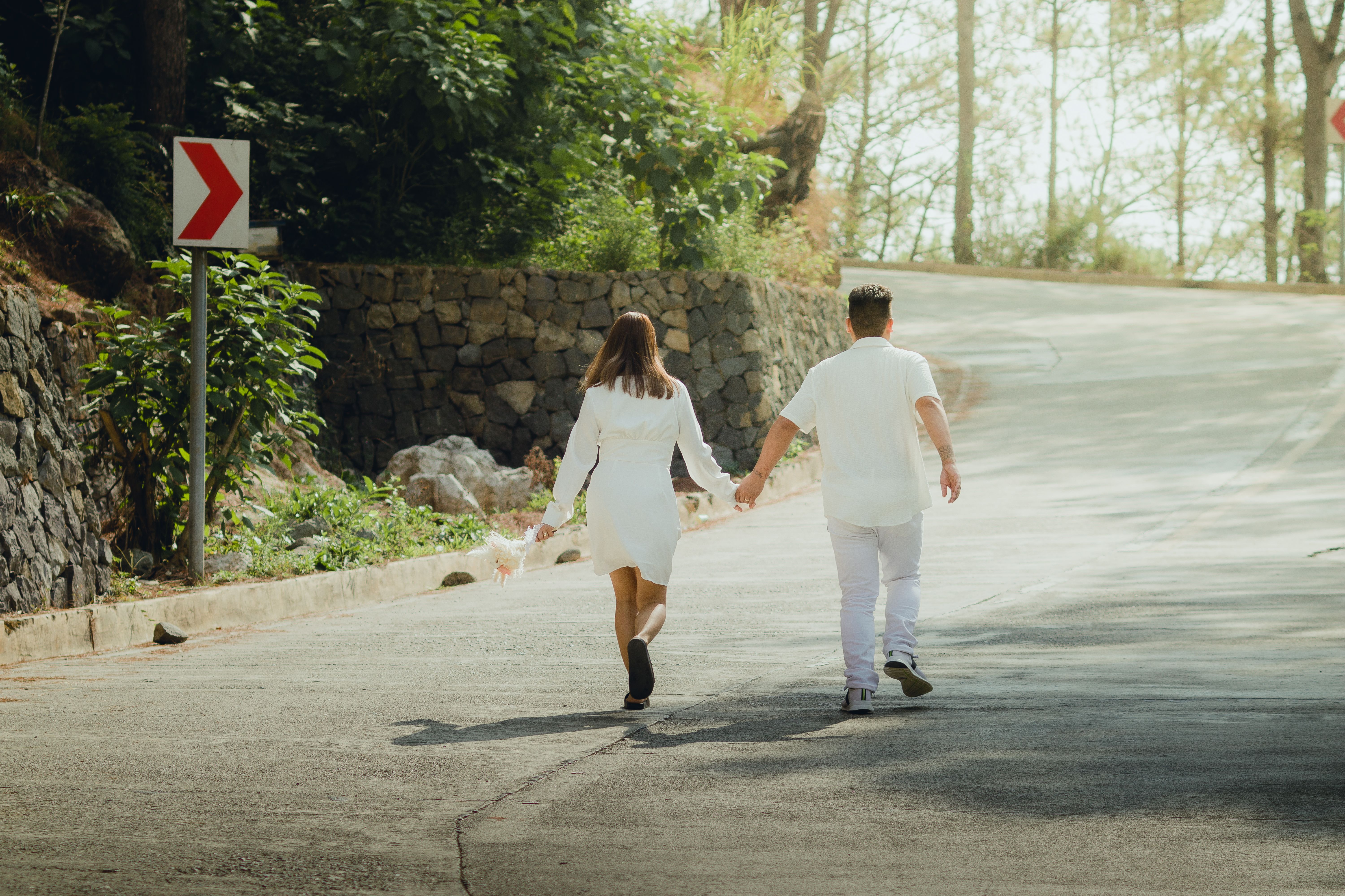 Couple Holding Hands and Walking on Road in Forest · Free Stock Photo