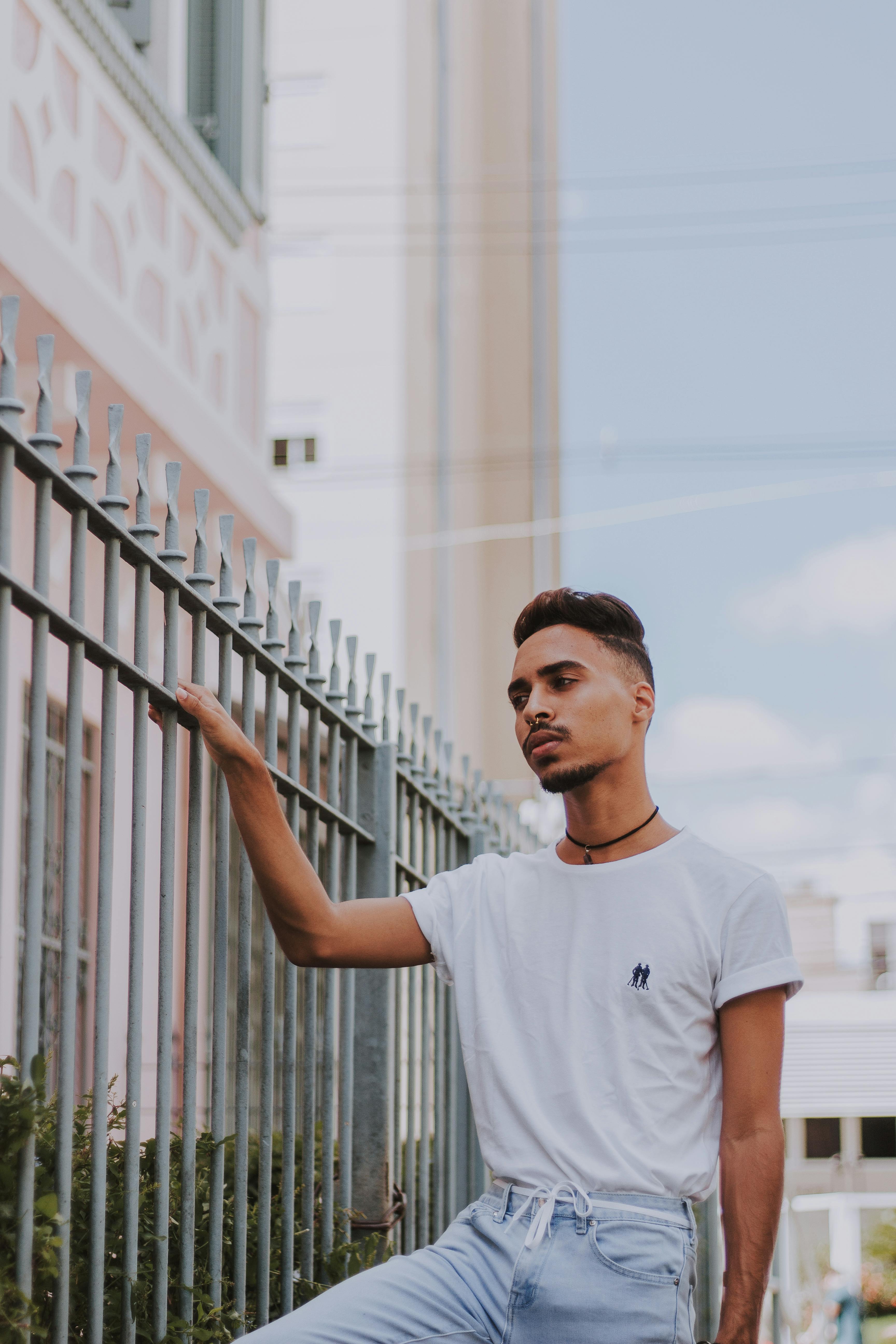 Man Standing Beside Gray Metal Gate