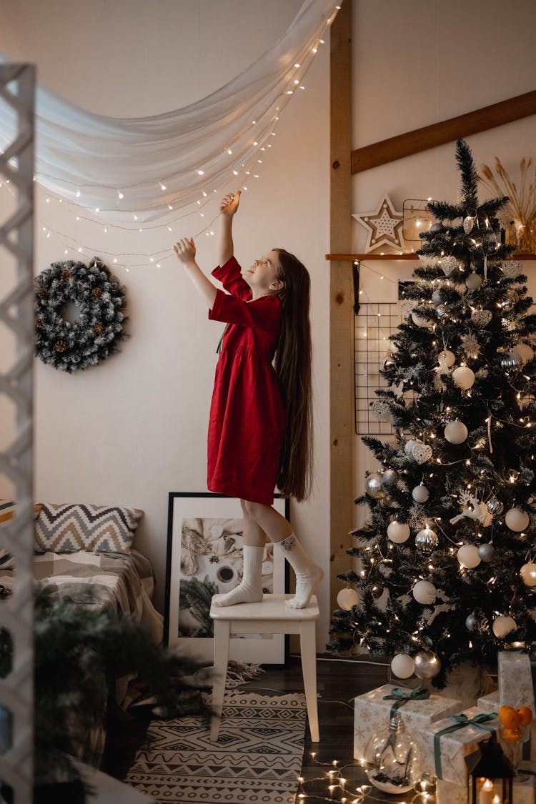 Girl Among Christmas Decoration In A Living Room 