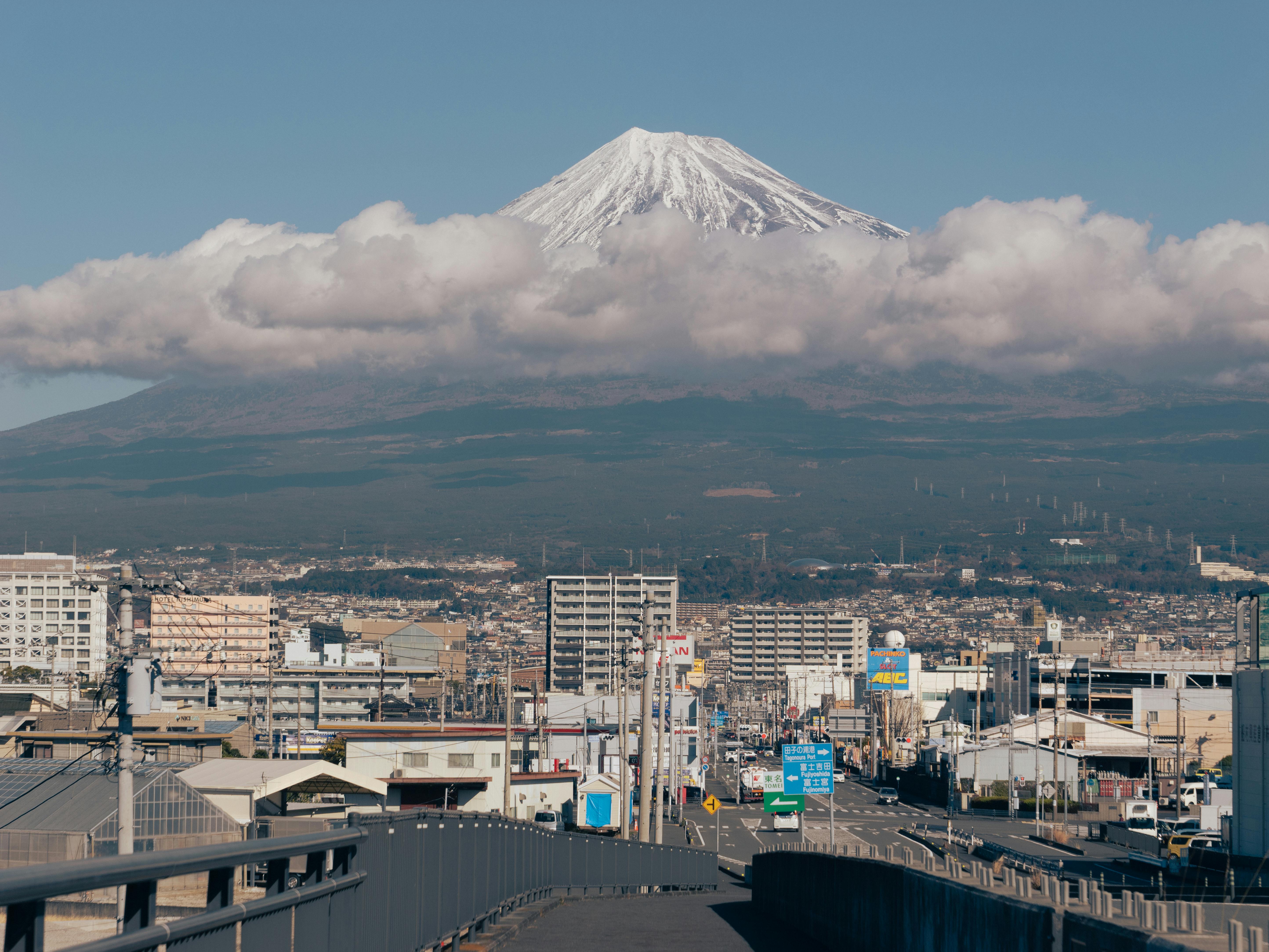A breathtaking view of Mount Fuji with a bustling cityscape in the foreground.
