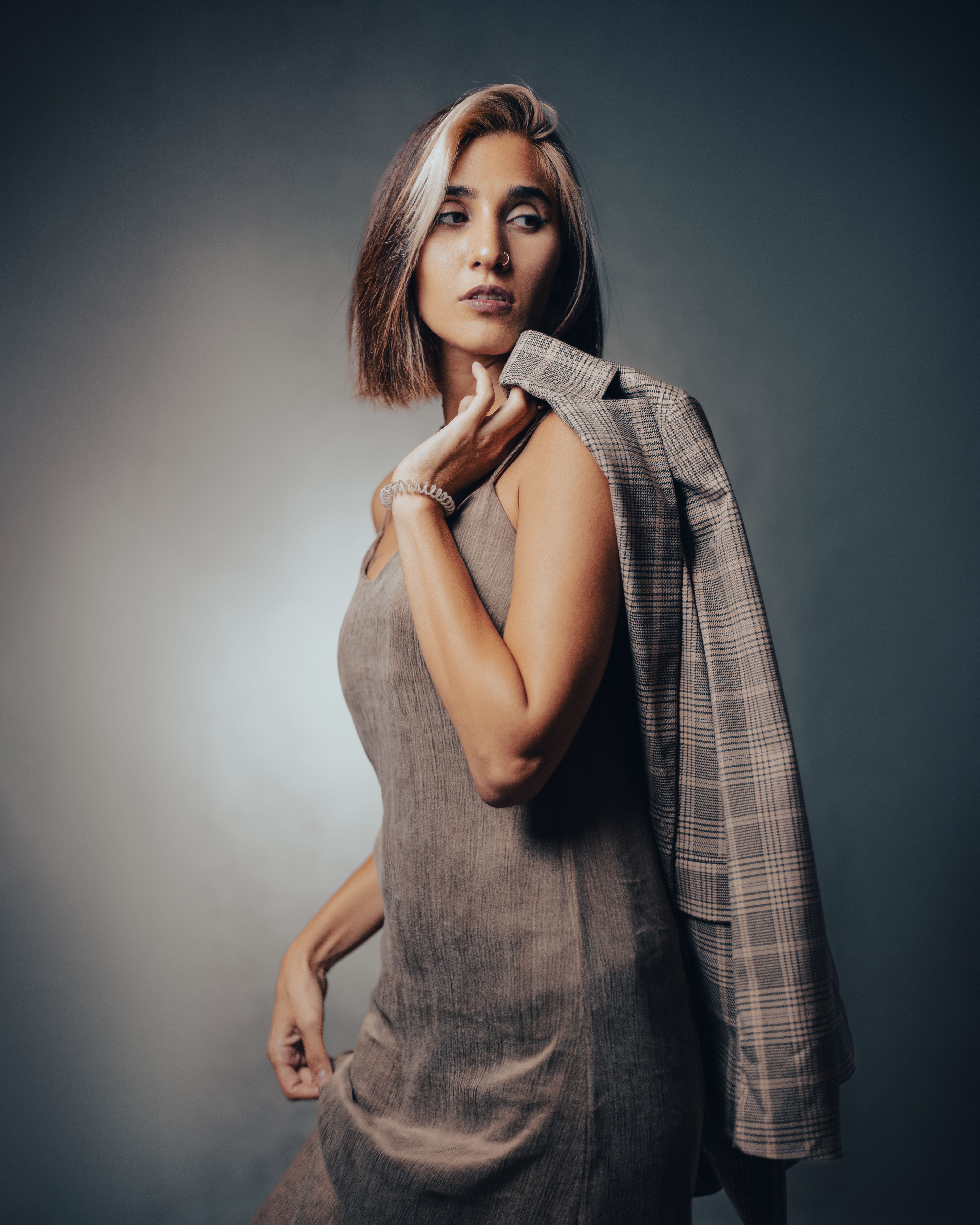 Woman in a dress with a blazer over her shoulder