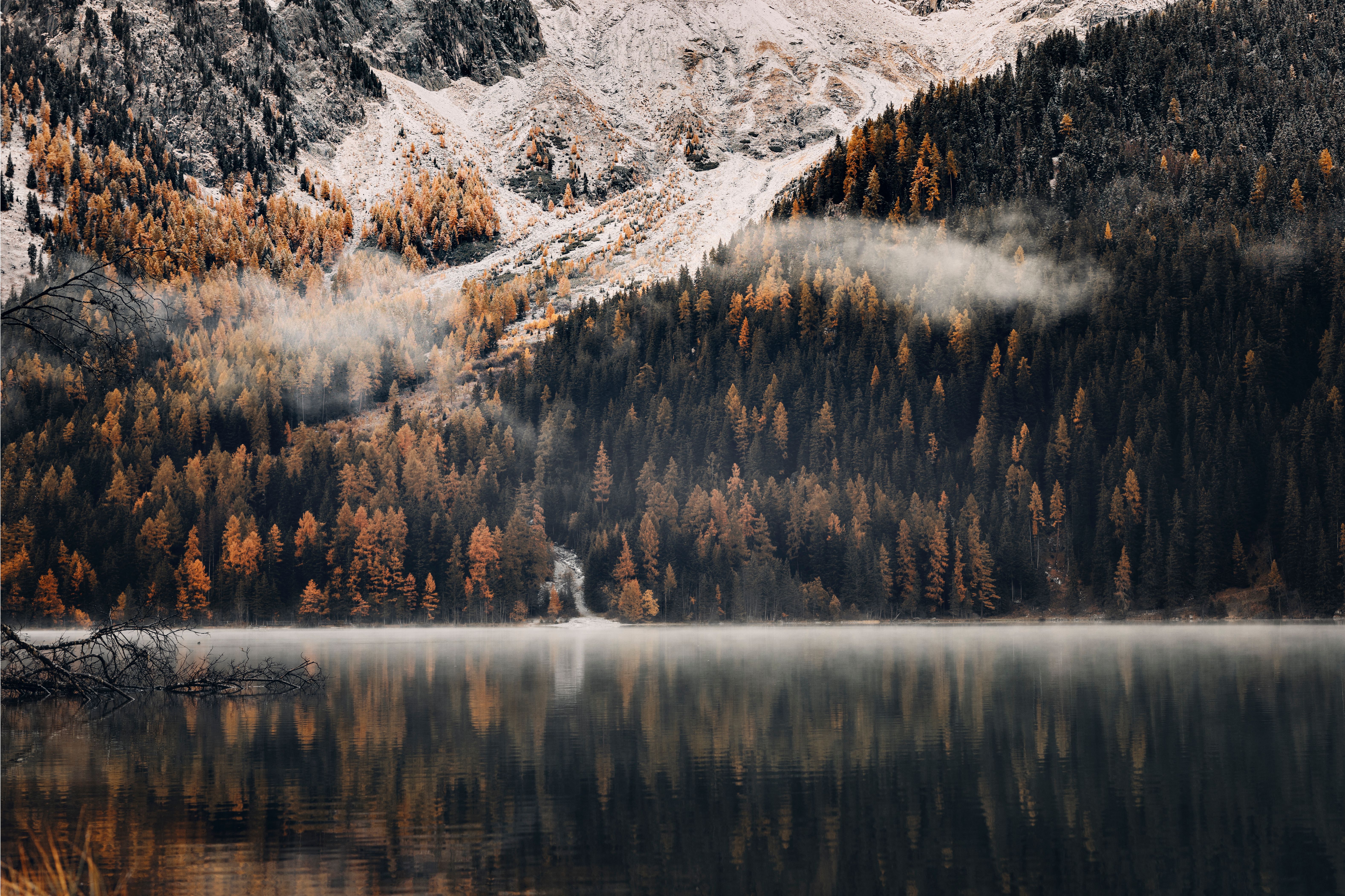 Tranquil winter landscape with snow-covered mountains and a reflecting lake.