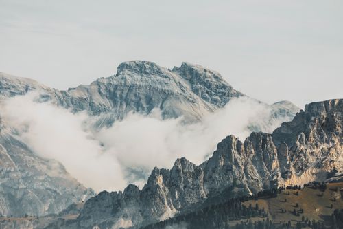 Free Majestic mountain landscape with dramatic peaks and swirling fog creating a serene, scenic view. Stock Photo