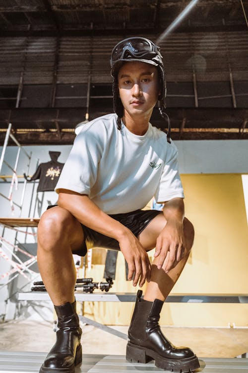 Male Model Wearing a Hat, a White T-shirt, Shorts and Black Boots