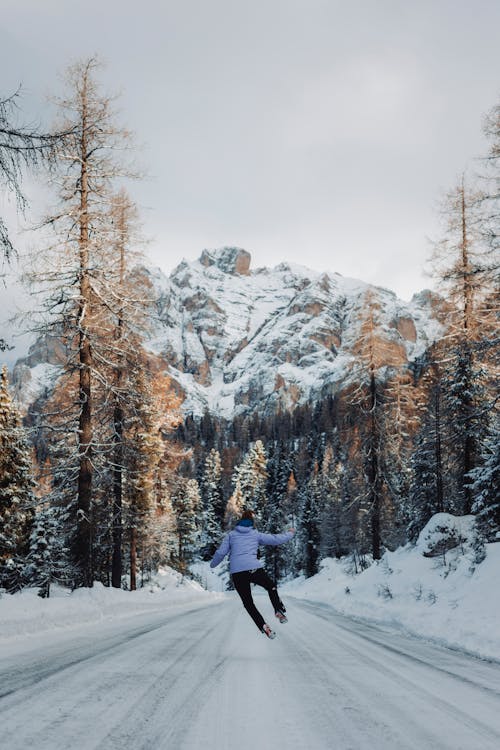 Person Jumping over Slippery Road in Winter