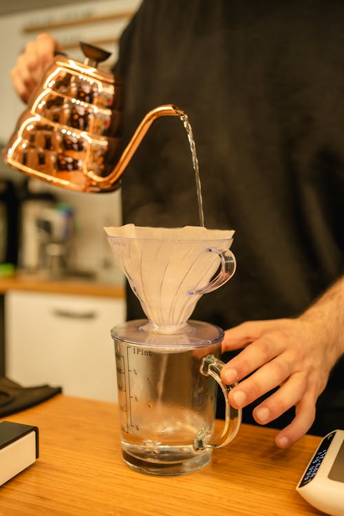 Man Pouring Water through Sieve to Pitcher