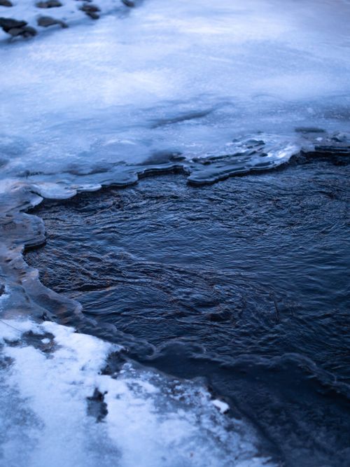 Free Captivating iced-over lake with intricate frozen patterns and deep blue hues. Stock Photo