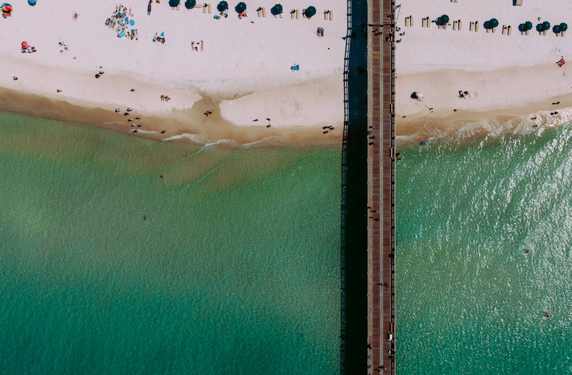 Aerial View of a Sunny Beach with Pier and Turquoise Waters