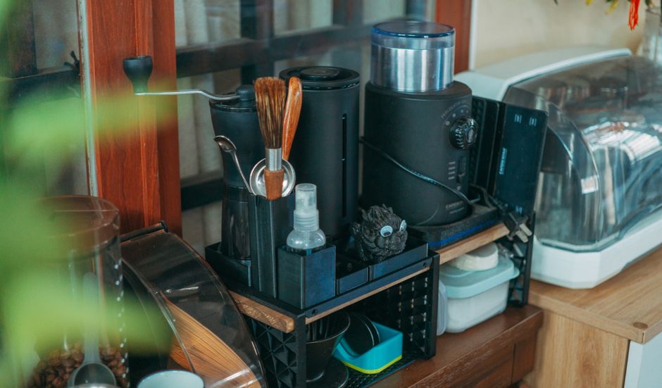 A tidy modern kitchen counter displaying various coffee-making equipment and kitchenware.