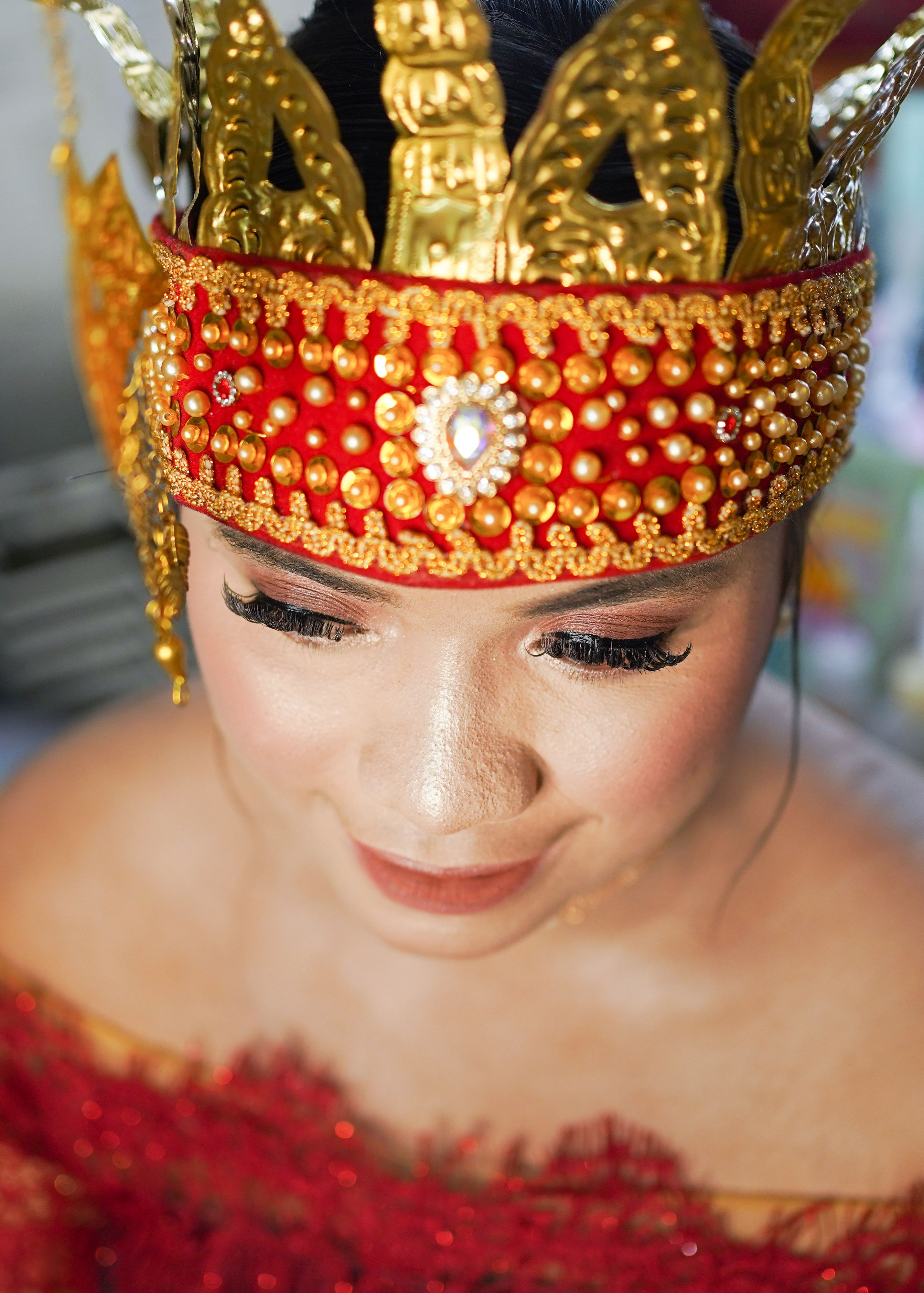 Portrait of a bride in ornate traditional attire, showcasing intricate jewelry and makeup.