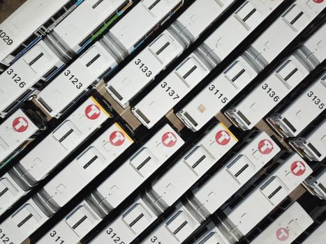 Drone shot of white buses parked at a transit hub, seen from above.