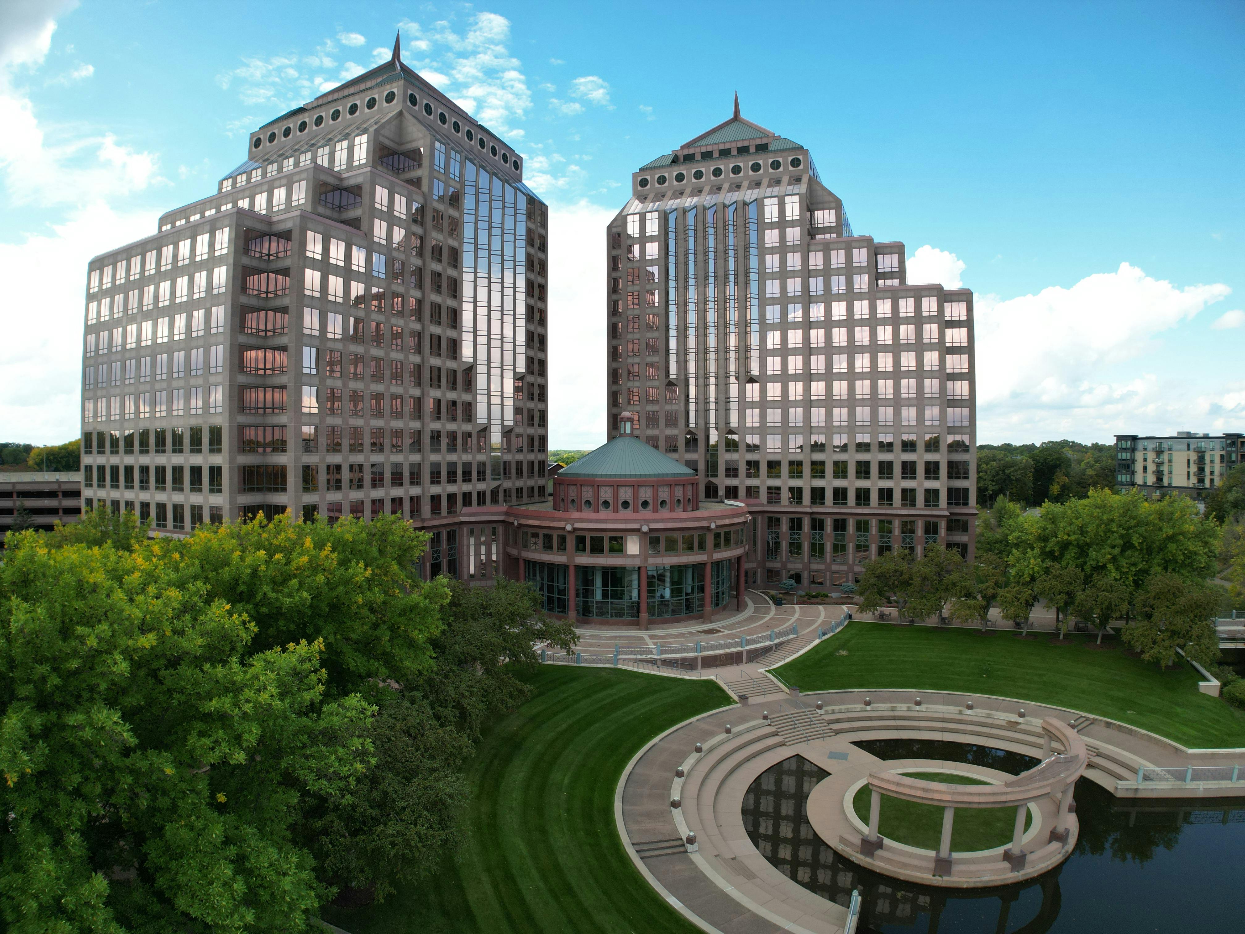 Modern office towers in a cityscape with landscaped garden. Captured from an aerial perspective.