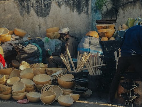 Man Among Handmade Bowls on a Bazaar 
