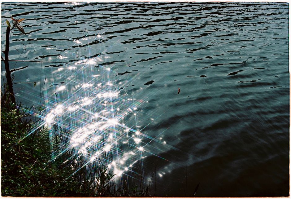 Sunlight sparkles on rippling water in Kon Tum, Vietnam, capturing nature's serenity.