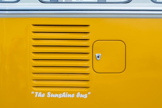 Detailed view of a yellow Volkswagen van side panel with 'The Sunshine Bus' text.