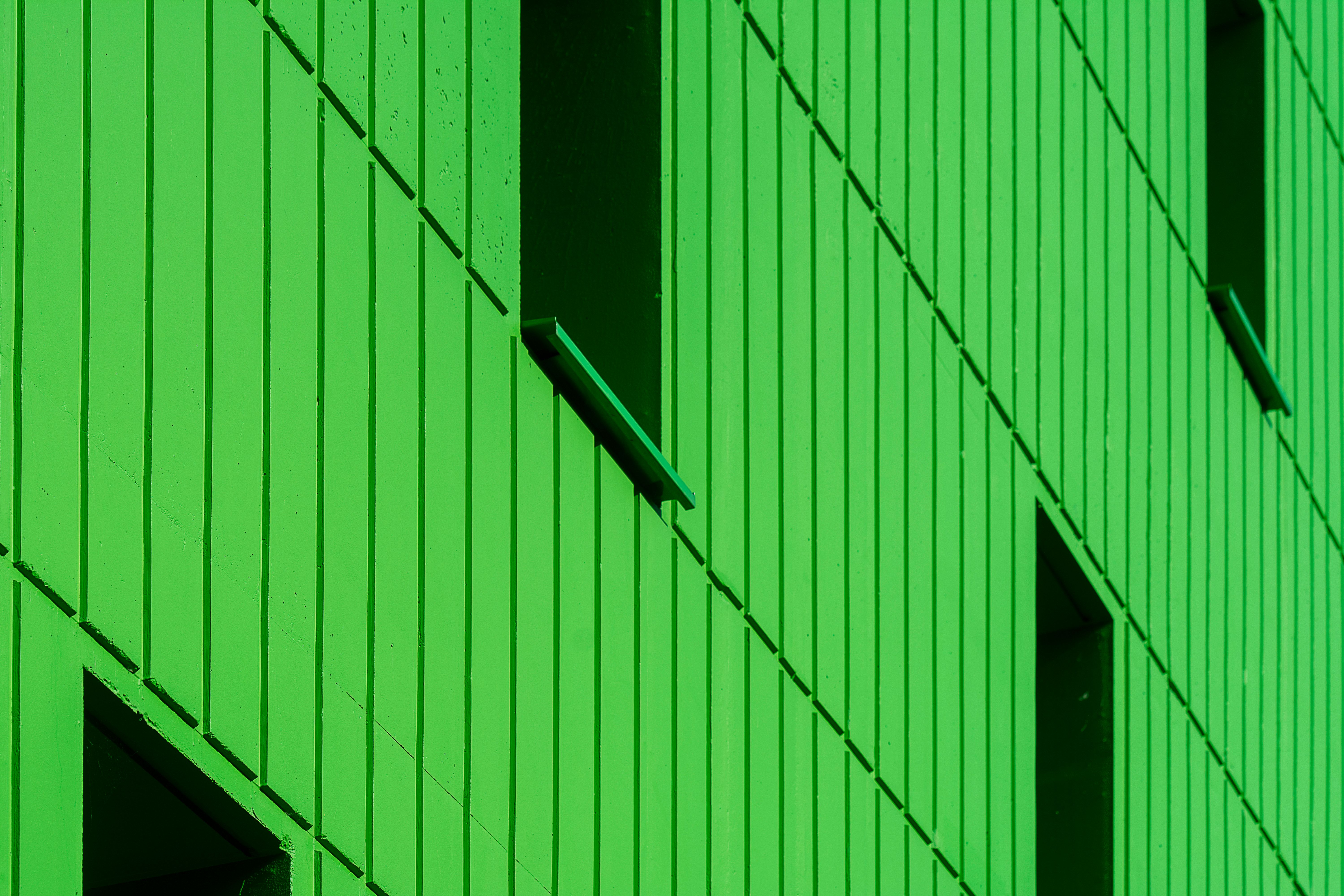 View of A green building with windows and a green wall · Free Stock Photo