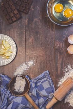 Top view of raw baking ingredients on a wooden table for a cozy kitchen scene.