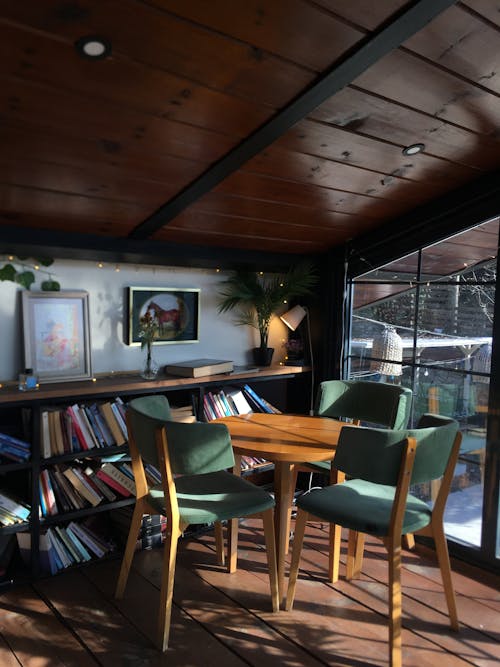 Table and Empty Chairs in Front of a Bookshelf