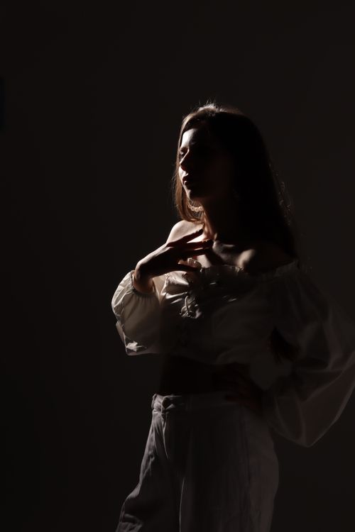 Free Artistic portrait of a woman with dramatic lighting, creating an elegant silhouette effect. Stock Photo