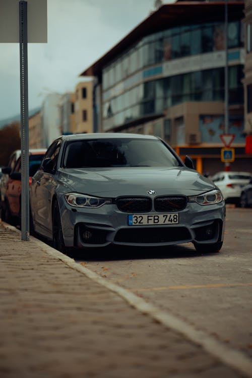 A Gray BMW M3 Parked on the Side of a Street in City 