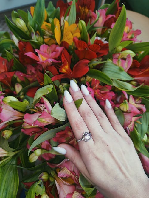 Close-up of Woman Wearing a Ring Touching a Colorful Bouquet 