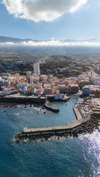 Scenic aerial shot of Puerto de la Cruz coastline, featuring cityscape and Mediterranean views.