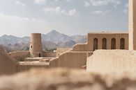 Traditional Omani fortress architecture with mountain backdrop, showcasing the cultural heritage of Nizwa.