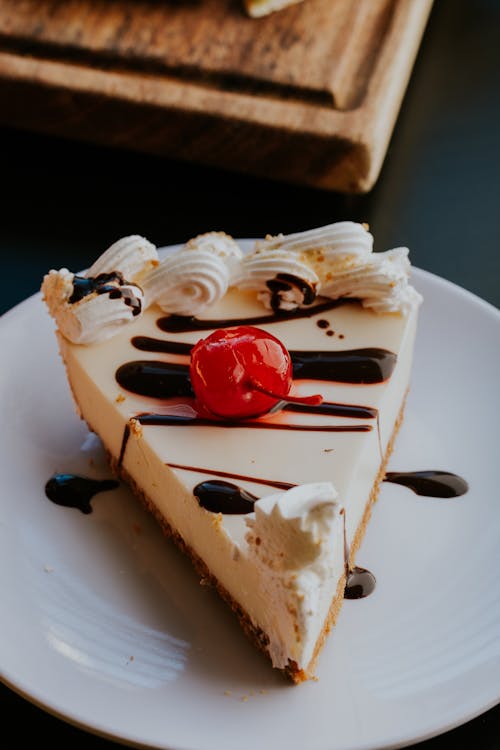 Slice of Cheesecake with Candied Cherry and Chocolate