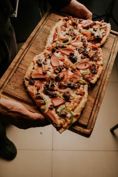 Freshly baked homemade pizza with toppings on a wooden tray, ready to serve.