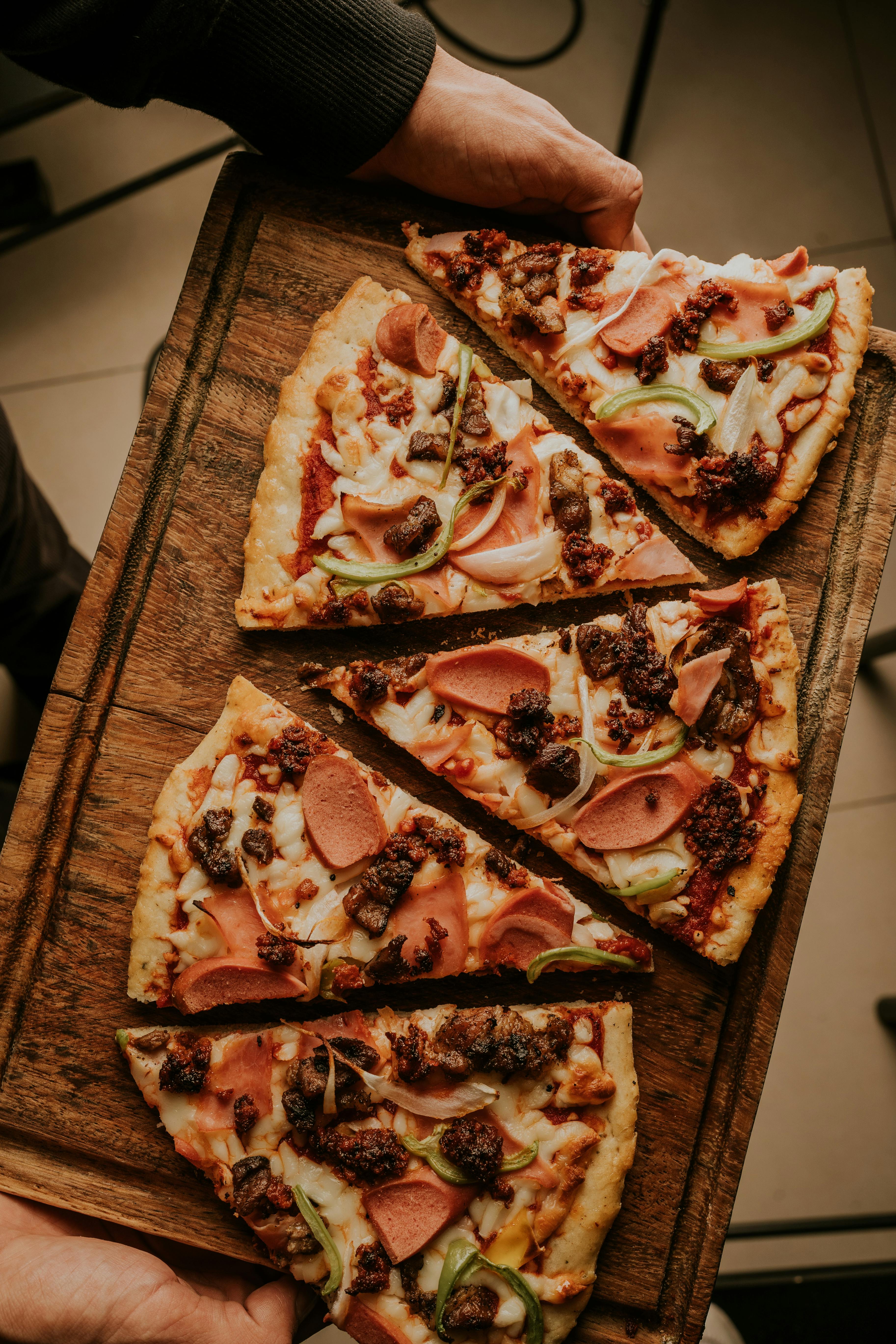 carrying a cutting board with slices of hot dog pizza