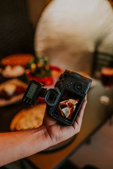 A photographer captures a delicious meal with a professional camera, showcasing food artistry.