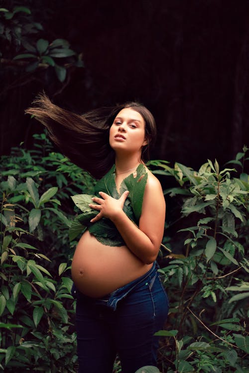 Pregnant Woman Among Tropical Leaves 