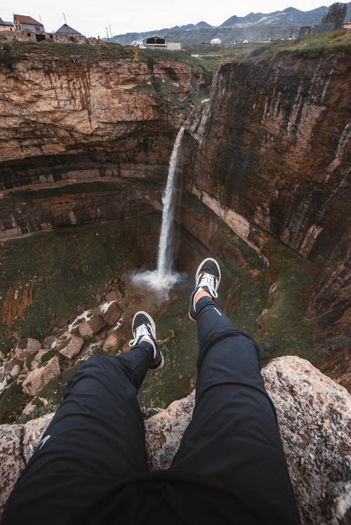 Man Sitting in Front of a Waterfall