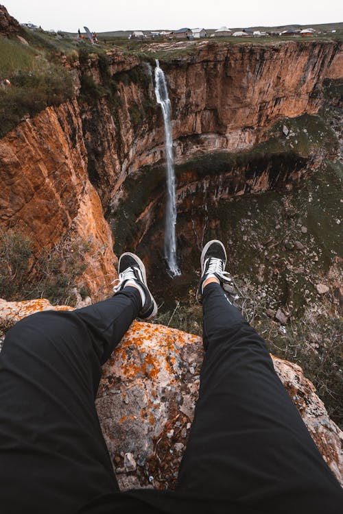 Man Sitting in Front of a Waterfall