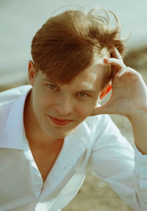 Free Portrait of a young redhead man smiling outdoors wearing a white shirt. Stock Photo